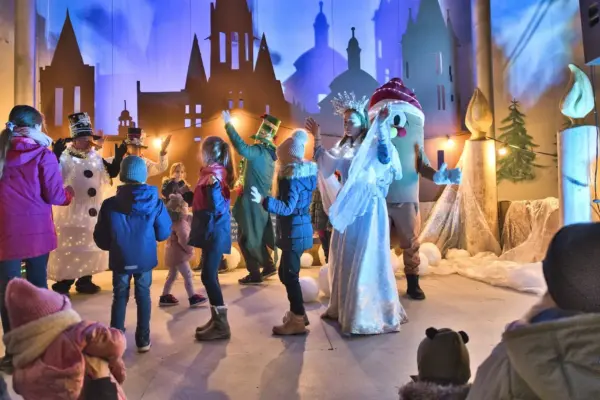 Kinder tanzen mit Christkind und Schneemann