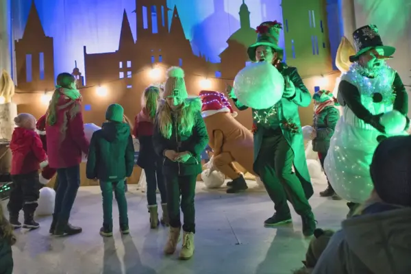 Weihnachtsshow in grünem Licht mit Schneemann und Kindern